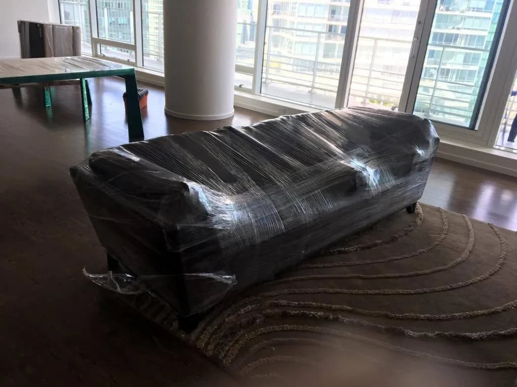 Sofa protected with moving blankets and wrapping for transport